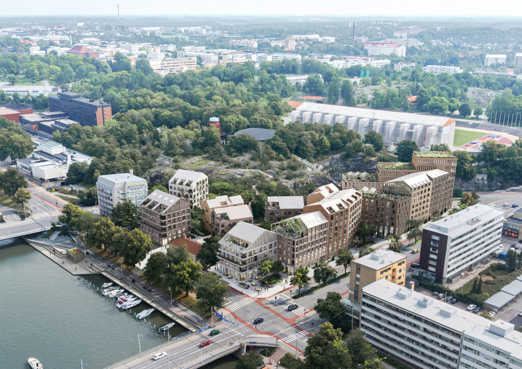 Ilmakuvassa näkyy risteys Turun jokirannassa. Risteykseen on havainnollistettu uusia puu- ja lasijulkisivuisia kerrostaloja, joissa on erilaisia viherkattoratkaisuja. Kerrostalojen takana näkyy puita ja kallioita ja oikealla urheilustadion.